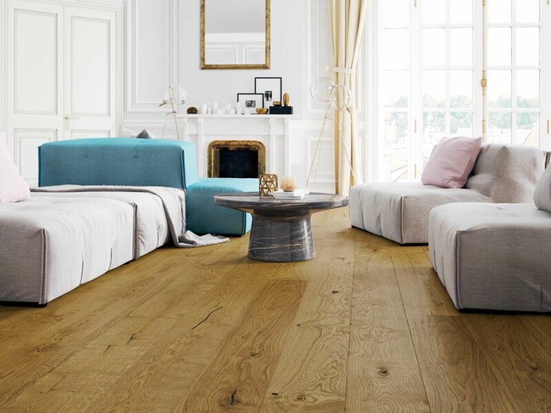 Modern living room with Driftwood Embered Oak wood flooring, grey sofa, and blue armchair.