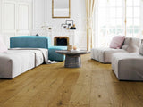 Modern living room with Driftwood Embered Oak wood flooring, grey sofa, and blue armchair.
