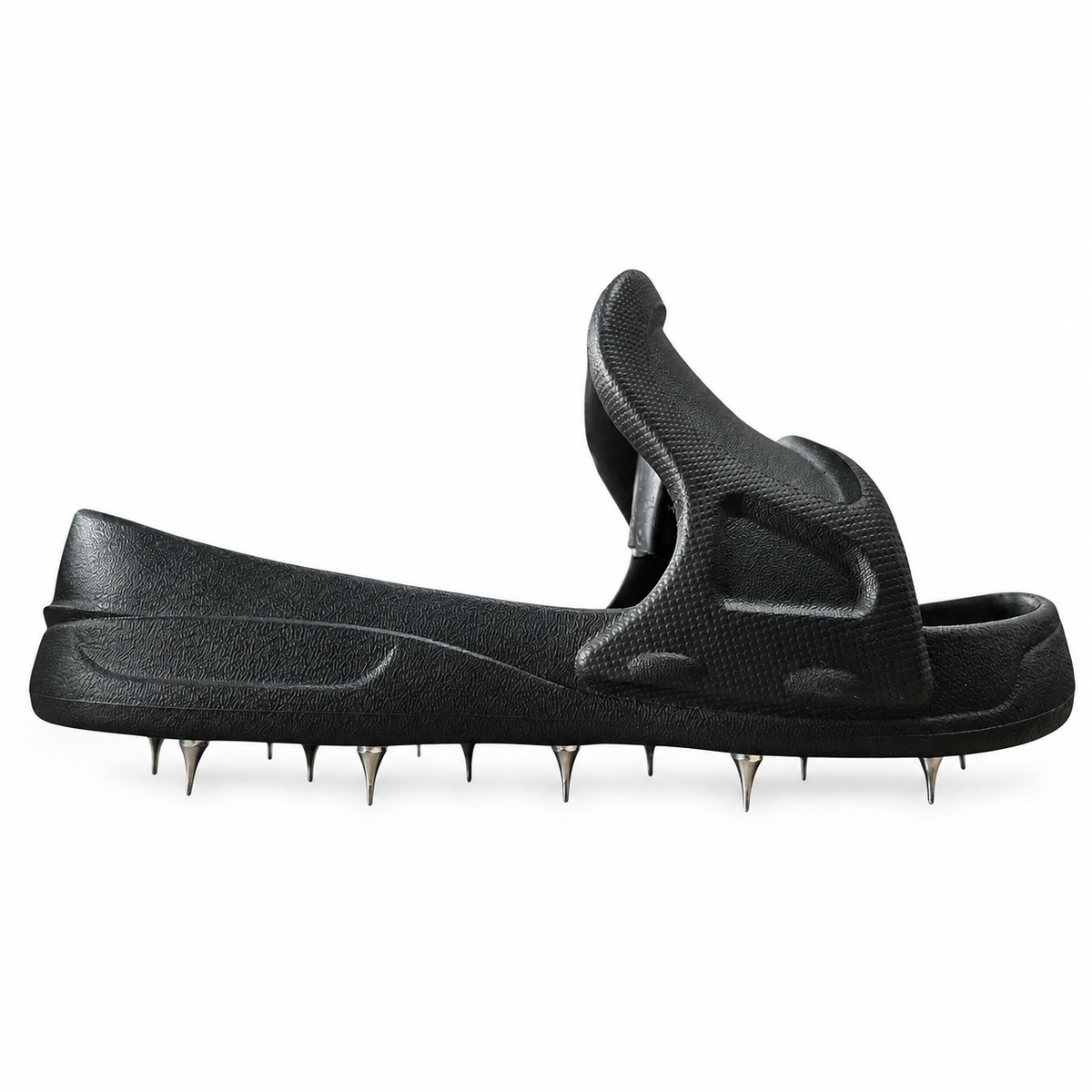 Side profile of a black slip-on spiked overshoe showing the moulded upper and metal spikes